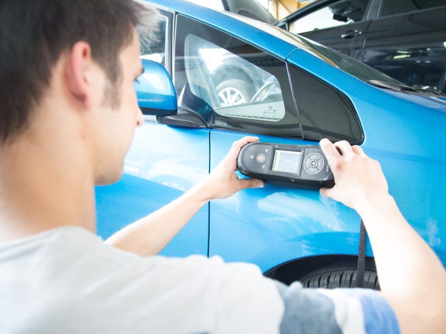 Qualifiziertes Personal Farbenfroher Papagei als Symbol für exakte Farbtöne bei der Autolackierung